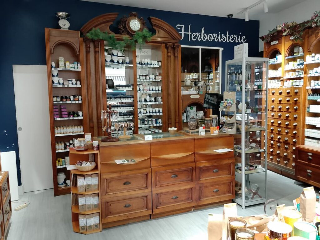 Intérieur de l'Herboristerie du Marais, montrant des étagères en bois remplies de produits naturels, un comptoir de style apothicaire et une ambiance traditionnelle et accueillante.